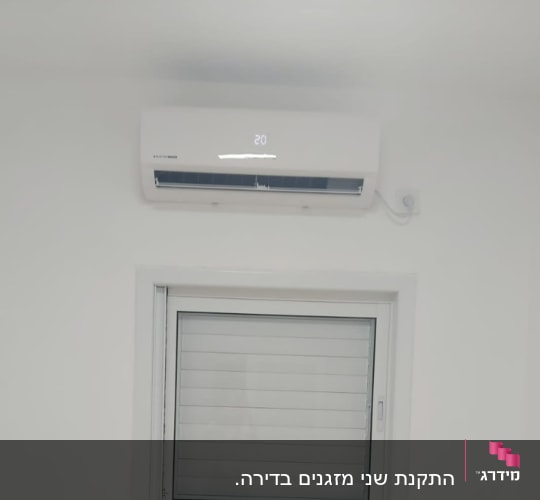 מזגן מותקן על קיר לבן עם תצוגת טמפרטורה